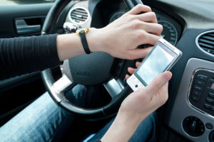 A driver looking at their smartphone while driving